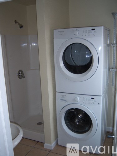 A white washing machine and dryer in a small bathroom.