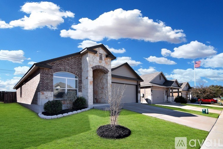 A house with a flag on the roof and a driveway leading to the garage.