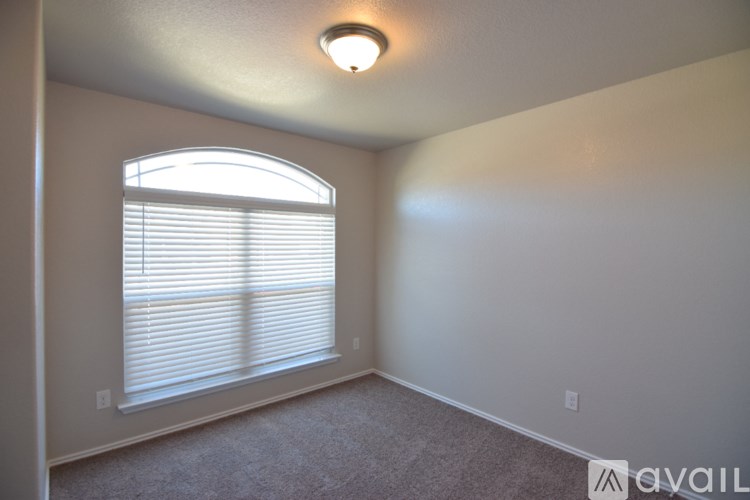 A room with a window covered by white blinds and a light on the ceiling.