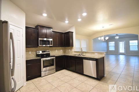 A kitchen with brown cabinets and a white refrigerator.