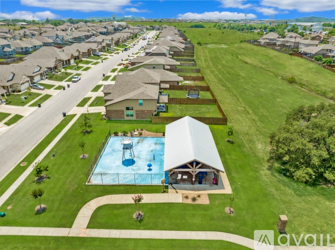 A bird's eye view of a neighborhood with a pool and a house with a covered patio.