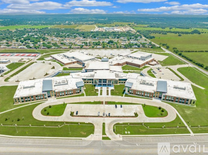 An aerial view of a large building complex surrounded by a green landscape.