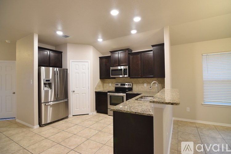 A kitchen with a granite countertop and stainless steel appliances.