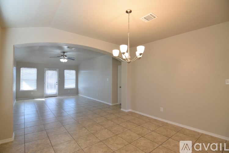 A spacious room with a chandelier and a ceiling fan.