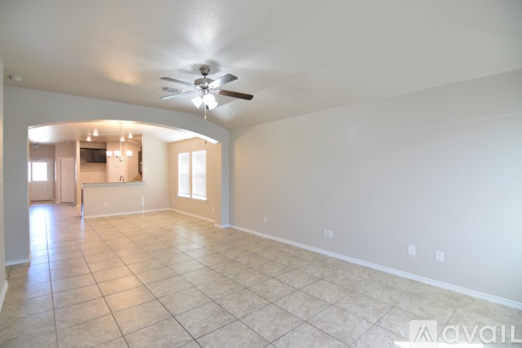 A spacious room with a ceiling fan and tiled flooring.