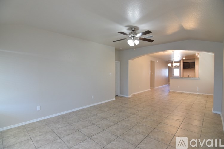 A spacious room with a ceiling fan and tiled floor.