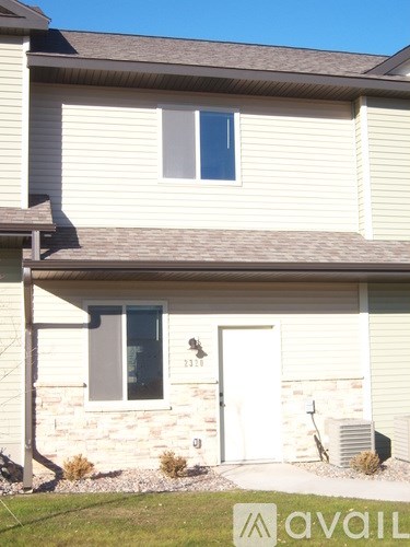 A house with a white door and a window with a black frame.