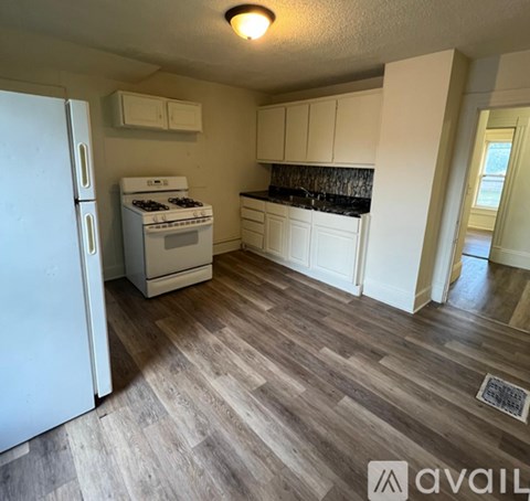 A kitchen with a white fridge, stove and cabinets.