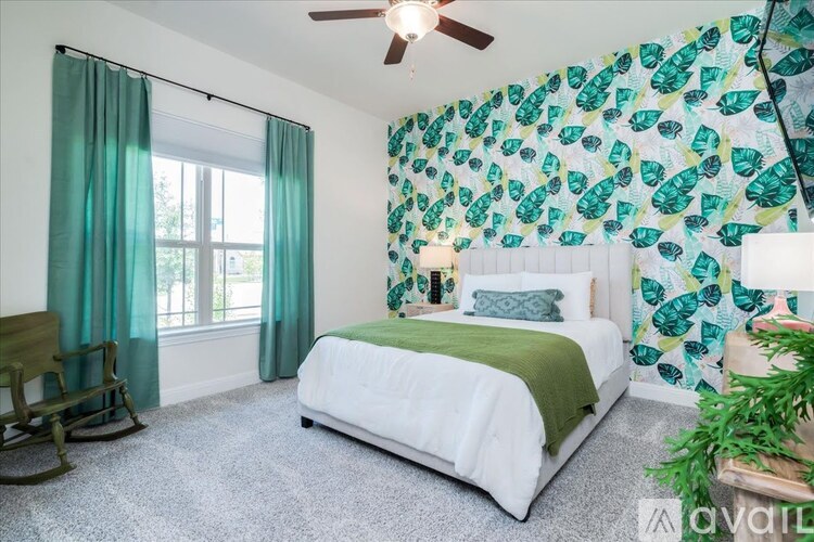 A bedroom with a white bed and green pillows.