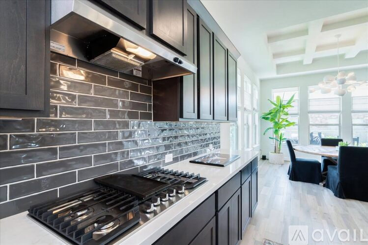 A modern kitchen with a black stove top oven and dark wood cabinets.
