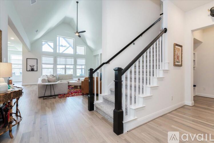 A living room with a white couch and a wooden floor.