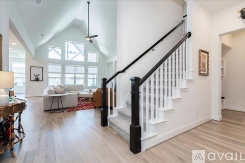 A living room with a white couch and a wooden floor.