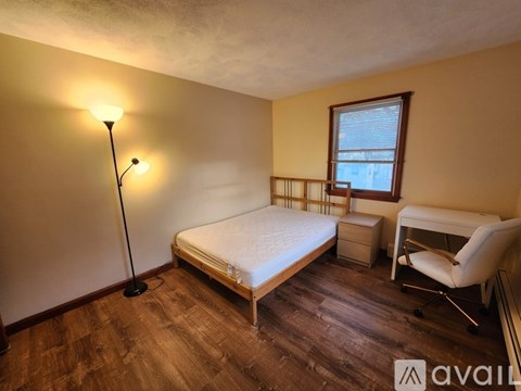 A bedroom with a bed, chair, and desk.