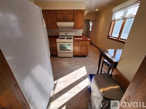 A kitchen with a white refrigerator and wooden cabinets.