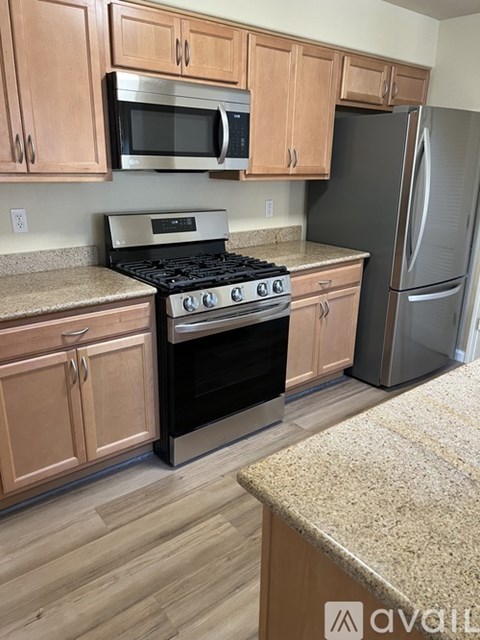 A kitchen with wooden cabinets and a granite countertop.
