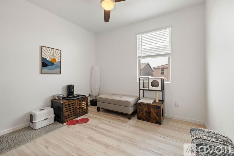 A living room with a sofa, a table, and a painting on the wall.