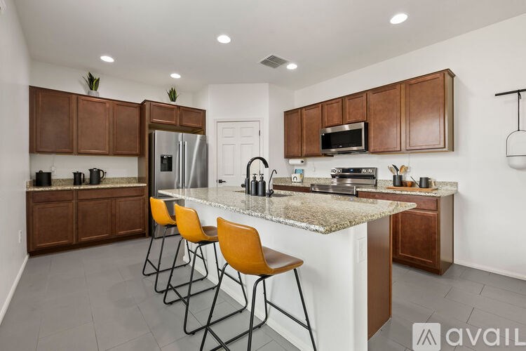 A kitchen with brown cabinets and a granite countertop.