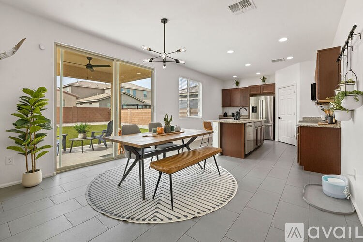 A modern kitchen with a dining table and chairs in the center of the room.