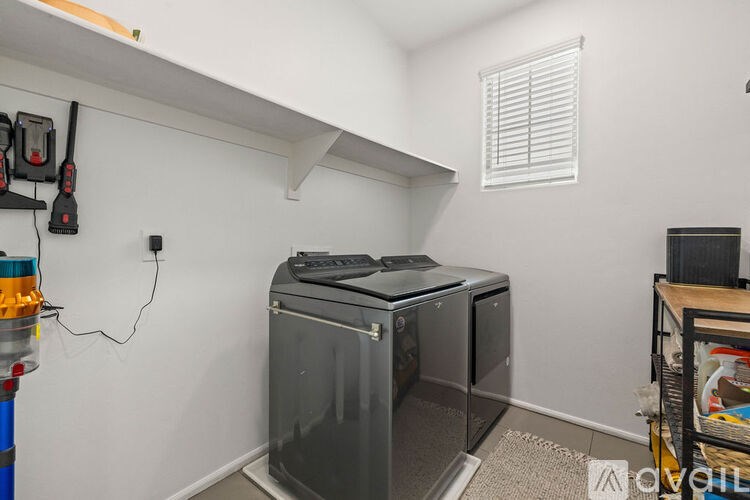 A room with a wall-mounted bike rack and a large, black, upright freezer.
