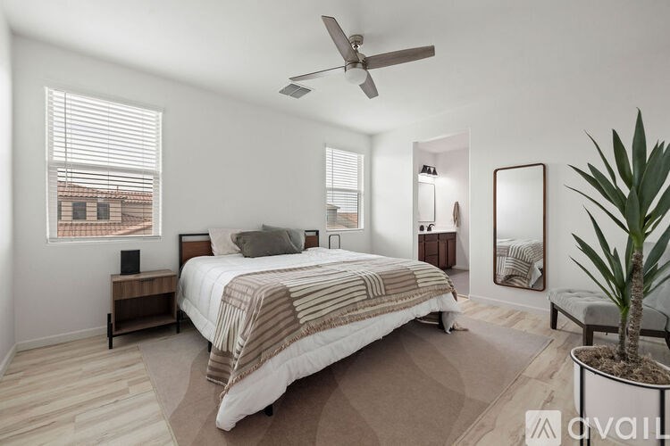 A bedroom with a large bed and a ceiling fan.