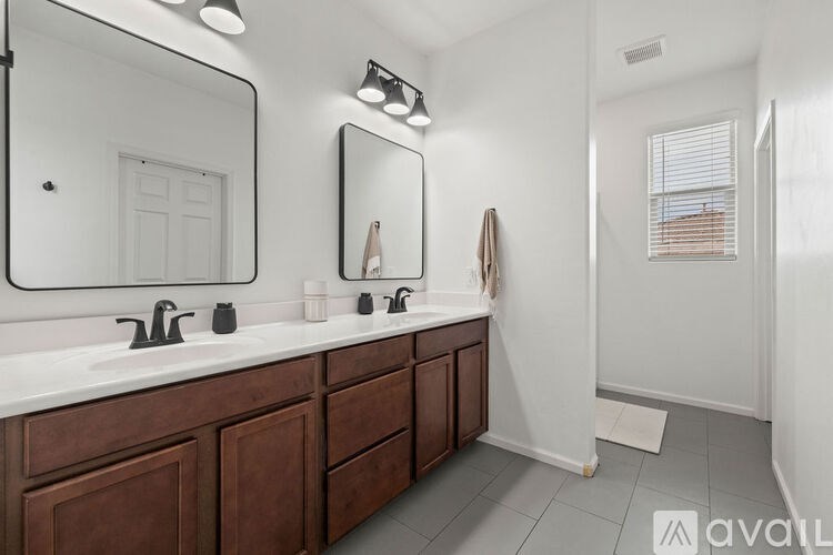 A bathroom with a white countertop and brown cabinets.