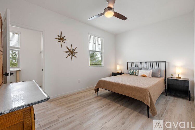 A bedroom with a bed, a ceiling fan, and a window.