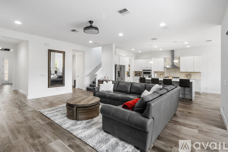 A modern kitchen with a large island and a refrigerator on the left.