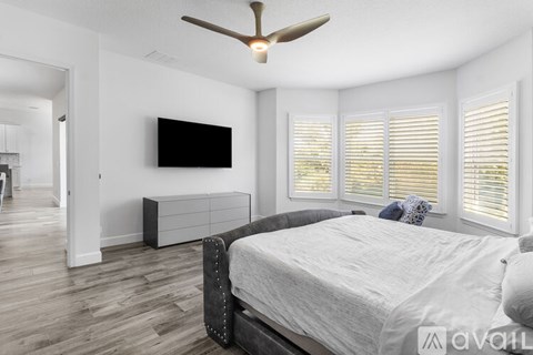 A bedroom with a large bed and a ceiling fan.