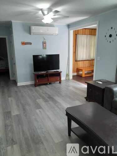 A living room with a television and a bench.