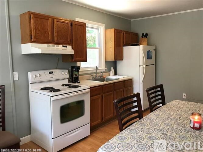 A kitchen with a white stove and a white refrigerator.