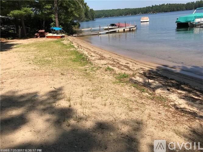 A beach with boats docked at the water's edge.