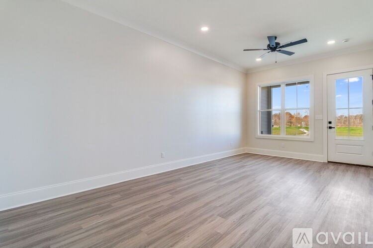 A room with a ceiling fan and a door leading outside.