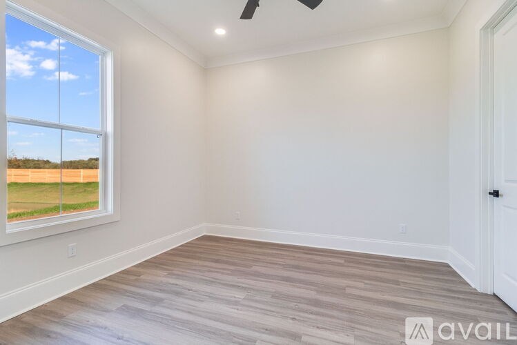 A room with a large window and a wooden floor.