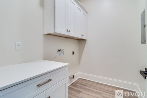 A kitchen with white cabinets and a white counter top.