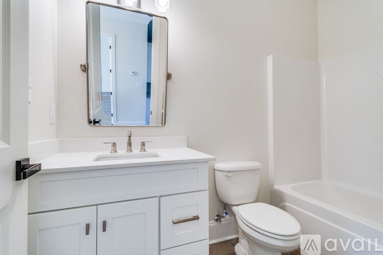 A white bathroom with a toilet, sink, and bathtub.