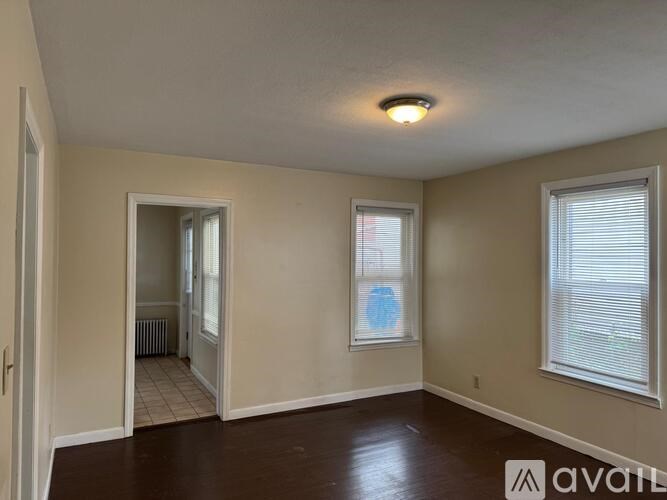 A room with a window and a door leading to another room.