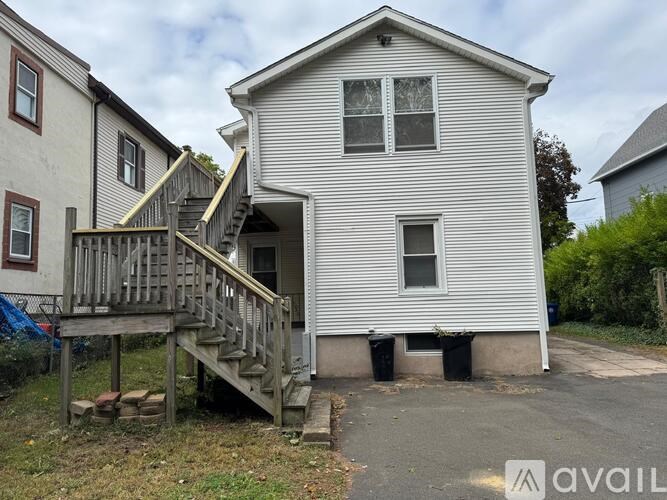 A two-story house with a wooden staircase leading to the upper level.