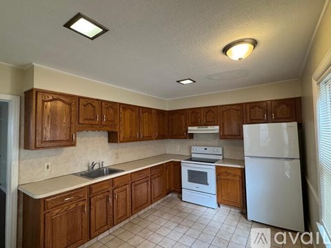 A kitchen with wooden cabinets and a white refrigerator.