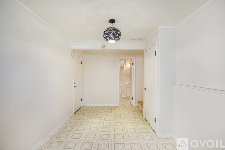 A hallway with a tiled floor and white walls.