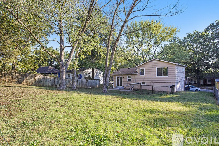 A house with a fence and trees in the yard.