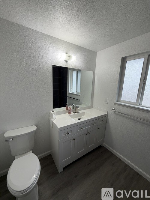 A spacious room with a carpeted floor and a window with a view of trees outside.