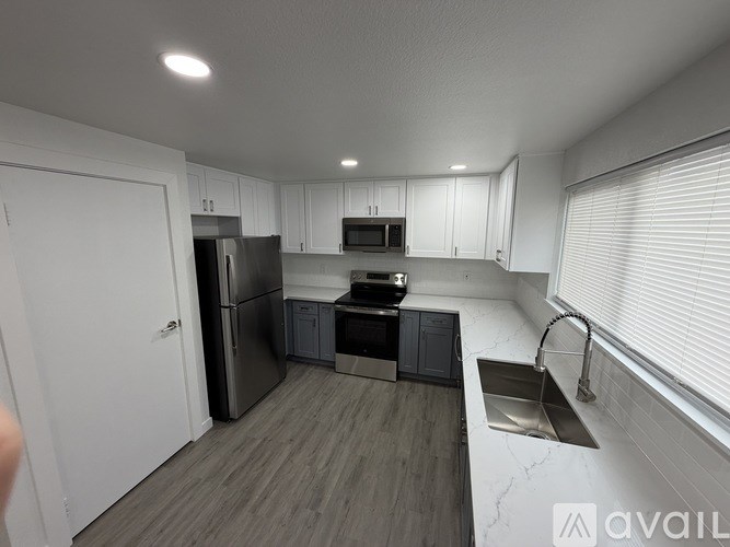 A modern kitchen with white cabinets and stainless steel appliances.