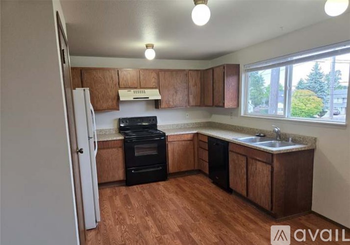 A kitchen with wooden cabinets and a black oven.