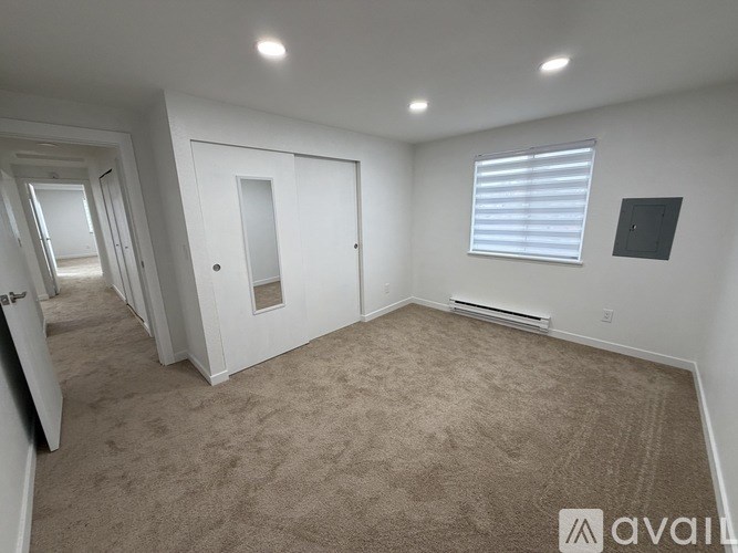 A room with a carpeted floor and a doorway leading to another room.