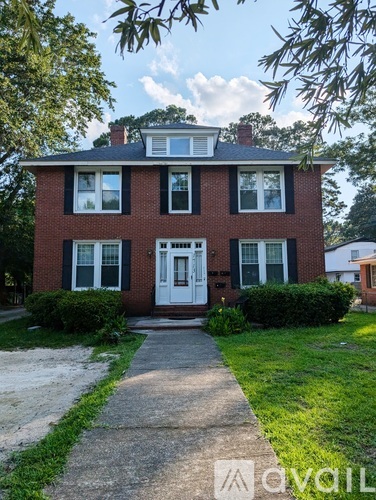 A red brick house with a white door and windows.