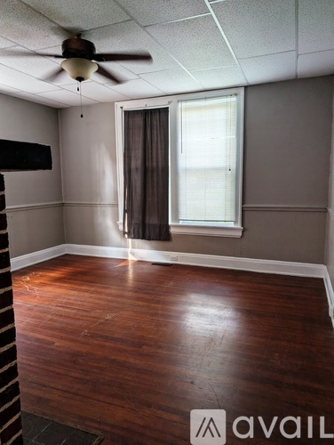 A room with a wooden floor and a ceiling fan.