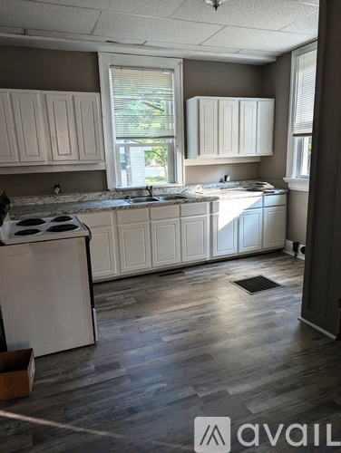 A kitchen with white cabinets and a black stove top.