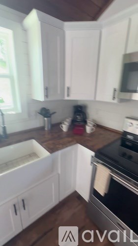A kitchen with white cabinets and a black stove top oven.
