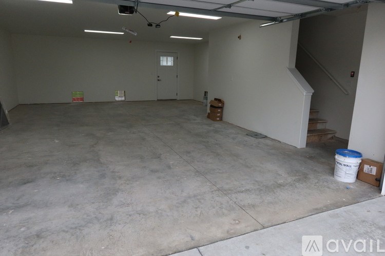 A room with wooden flooring and a window with blinds.