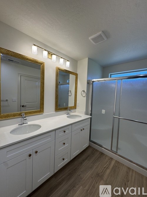 A bathroom with two sinks and a large mirror.